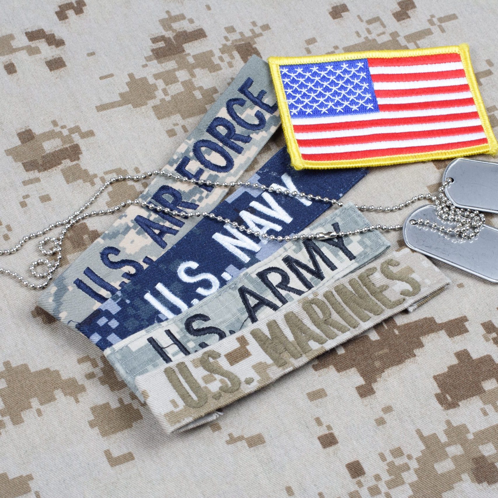 US MILITARY concept with branch tapes and dog tags on camouflage uniform background